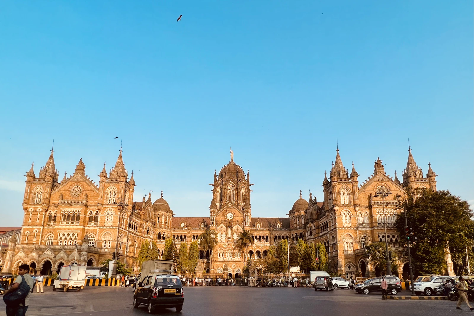 The Victorian Gothic facade and central clock tower of Chhatrapati Shivaji Maharaj Terminus in Mumbai at golden hour